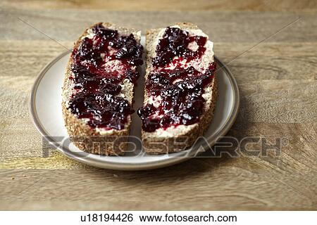 Stock Photograph - Berry jam on rustic bread. Fotosearch