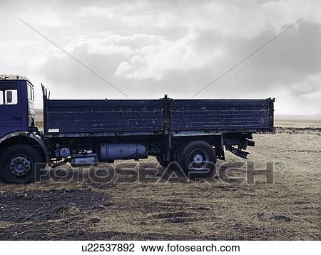 Stock Image - Blue truck parked in dry field. Fotosearch
