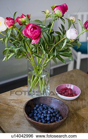 Bowls of fruit with vase of flowers View Large Photo Image Stock Photograph - Bowls of fruit with vase of flowers. Fotosearch