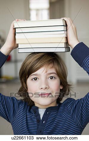 Boy balancing books on his head View Large Photo Image Stock Image - Boy balancing books on his head. Fotosearch
