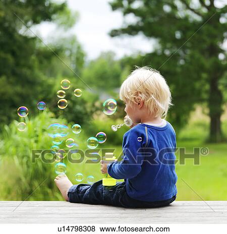 Boy blowing bubbles on porch View Large Photo Image Stock Photo - Boy blowing bubbles on porch. Fotosearch
