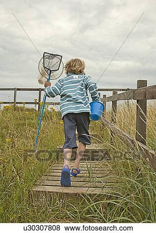 Boy carrying nets and pail outdoors View Large Photo Image Stock Photo - Boy carrying nets and pail outdoors. Fotosearch
