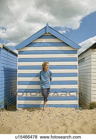 Boy leaning against shack on beach View Large Photo Image Stock Photo - Boy leaning against shack on beach. Fotosearch