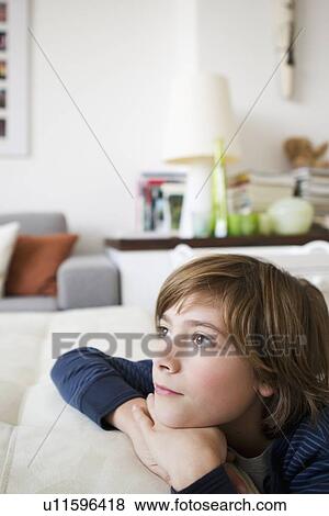Boy relaxing on sofa in living room View Large Photo Image Stock Photo - Boy relaxing on sofa in living room. Fotosearch