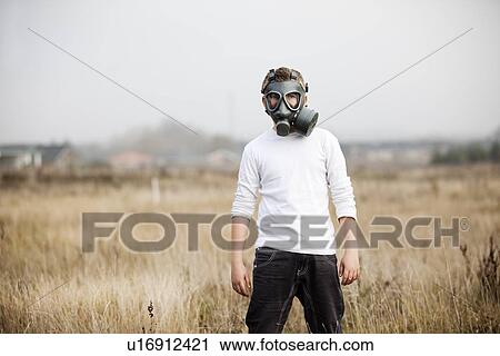 Stock Image - Boy wearing gas mask in wheatfield. Fotosearch