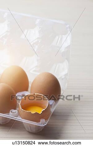 Picture - Broken egg in plastic egg crate. Fotosearch