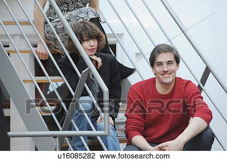 Stock Image - Business people sitting on office steps. Fotosearch