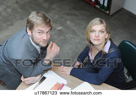 Stock Image - Business people talking at desk. Fotosearch