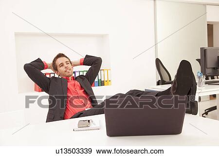 Businessman relaxing at desk View Large Photo Image Stock Photo - Businessman relaxing at desk. Fotosearch