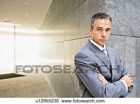 Businessman standing in office View Large Photo Image Stock Image - Businessman standing in office. Fotosearch