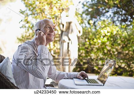 Stock Image - Businessman talking on cell phone. Fotosearch