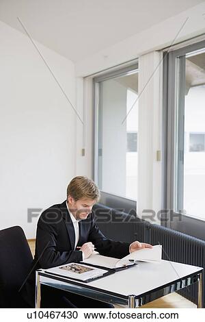 Businessman working at desk in office View Large Photo Image Stock Image - Businessman working at desk in office. Fotosearch