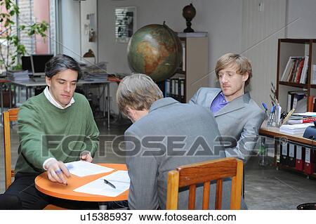 Businessmen working together at desk View Large Photo Image Stock Photo - Businessmen working together at desk. Fotosearch