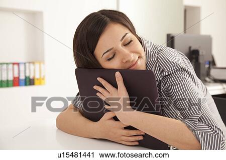 Businesswoman hugging computer in office View Large Photo Image Stock Image - Businesswoman hugging computer in office. Fotosearch