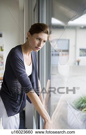 Businesswoman looking out office window View Large Photo Image Stock Image - Businesswoman looking out office window. Fotosearch