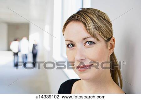 Stock Image - Businesswoman smiling in office. Fotosearch