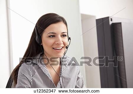 Businesswoman talking on headset at desk View Large Photo Image Stock Photo - Businesswoman talking on headset at desk. Fotosearch