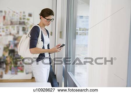 Businesswoman using cell phone in office View Large Photo Image Stock Photo - Businesswoman using cell phone in office. Fotosearch