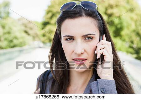 Stock Photography - Businesswoman using cell phone outdoors. Fotosearch