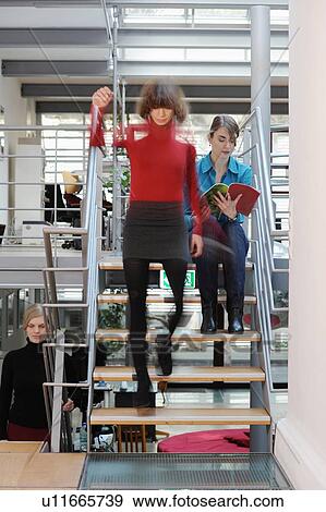 Stock Photo - Businesswomen on steps in office. Fotosearch