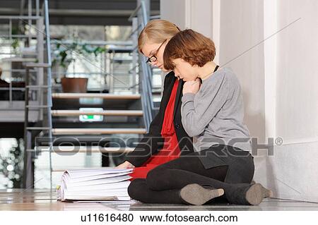 Businesswomen reading book on floor View Large Photo Image Stock Image - Businesswomen reading book on floor. Fotosearch