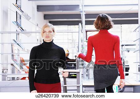 Stock Photo - Businesswomen walking in office. Fotosearch