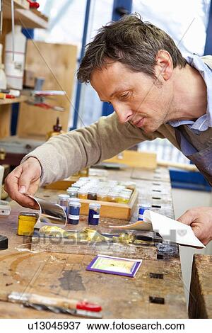Stock Photo - Carpenter matching pigment to paint. Fotosearch