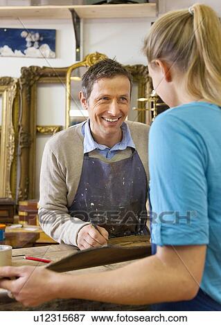 Carpenter talking to woman in shop View Large Photo Image Stock Photo - Carpenter talking to woman in shop. Fotosearch