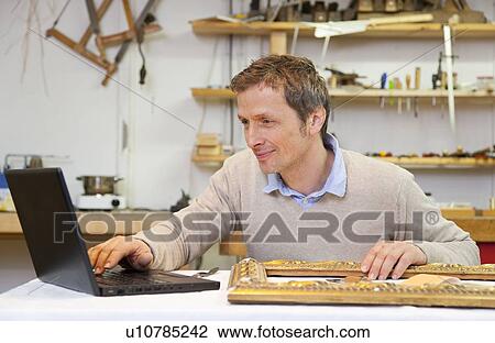 Carpenter working on laptop in shop View Large Photo Image Stock Image - Carpenter working on laptop in shop. Fotosearch