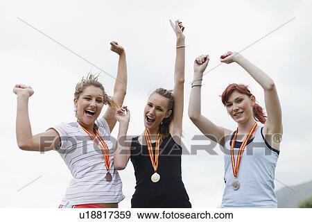 Cheering women wearing medals in park View Large Photo Image Stock Photo - Cheering women wearing medals in park. Fotosearch