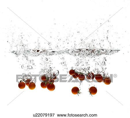 Stock Photo - Cherry tomatoes splashing in water. Fotosearch