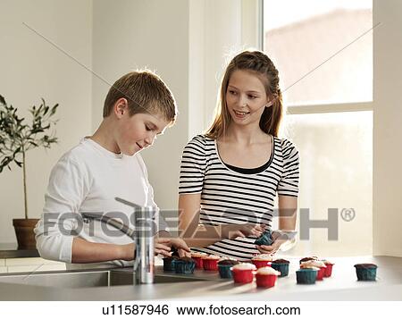 Stock Photograph - Children decorating cupcakes together. Fotosearch