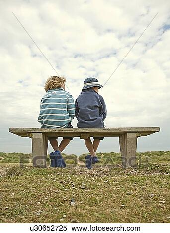 Children sitting on bench outdoors View Large Photo Image Stock Photography - Children sitting on bench outdoors. Fotosearch