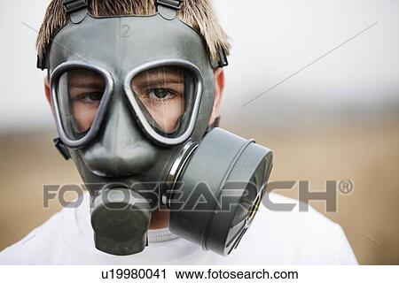 Stock Image - Close up of boy wearing gas mask. Fotosearch