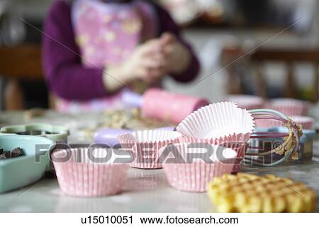 Stock Image - Close up of cupcake wrappers in kitchen. Fotosearch