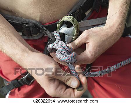 Picture - Close up of rock climber tying knot. Fotosearch