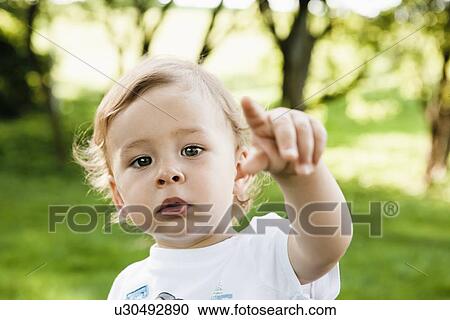 Close up of toddler pointing in park View Large Photo Image Stock Image - Close up of toddler pointing in park. Fotosearch