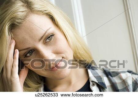Stock Image - Close up of woman rubbing her forehead. Fotosearch