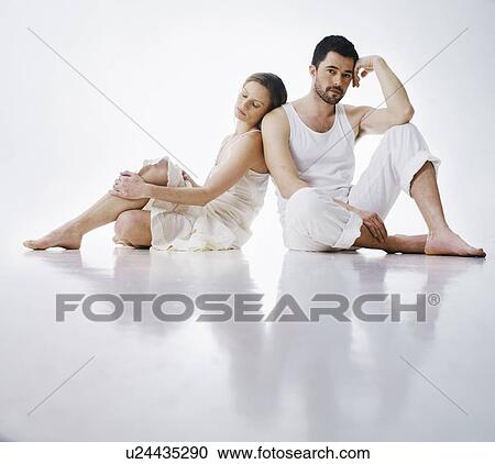 Stock Image - Couple sitting together on floor. Fotosearch
