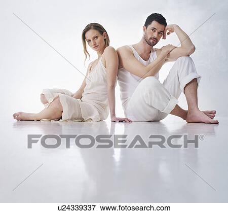 Couple sitting together on floor View Large Photo Image Stock Photo - Couple sitting together on floor. Fotosearch