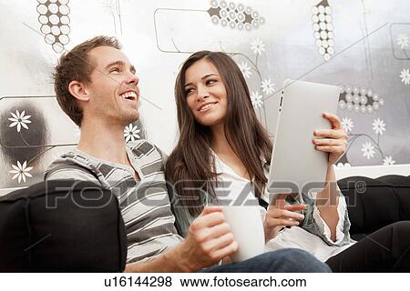 Couple using tablet computer together View Large Photo Image Stock Photo - Couple using tablet computer together. Fotosearch