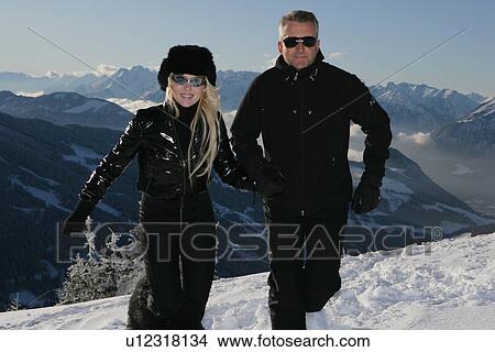 Couple walking on snowy mountainside View Large Photo Image Picture - Couple walking on snowy mountainside. Fotosearch