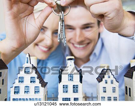 Couple with keys and model houses View Large Photo Image Stock Photography - Couple with keys and model houses . Fotosearch