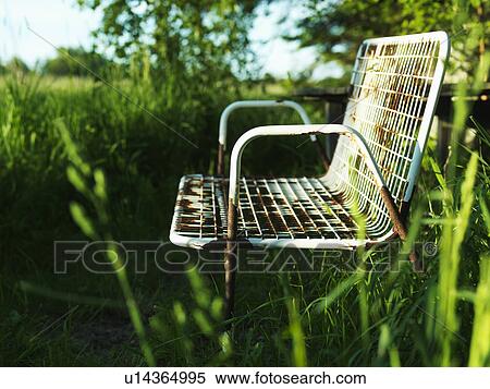 Stock Photography - Empty park bench in grass. Fotosearch