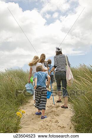 Stock Image - Family walking on beach together. Fotosearch