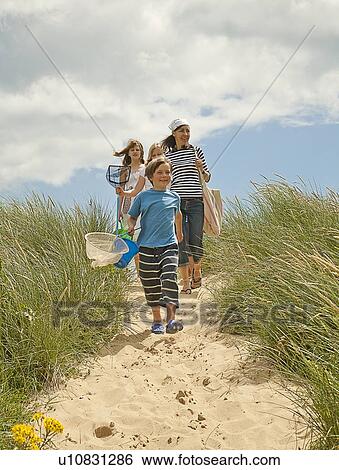 Stock Photograph - Family walking on beach together. Fotosearch