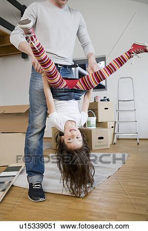 Stock Image - Father and daughter playing in new house. Fotosearch