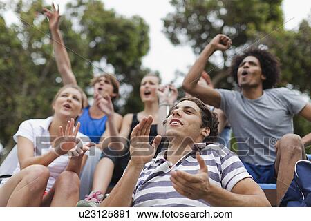 Friends cheering at sporting event View Large Photo Image Stock Image - Friends cheering at sporting event. Fotosearch