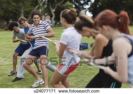 Friends playing tug of war in park View Large Photo Image Stock Image - Friends playing tug of war in park. Fotosearch