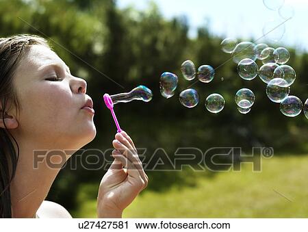 Girl blowing bubbles outdoors View Large Photo Image Stock Image - Girl blowing bubbles outdoors. Fotosearch